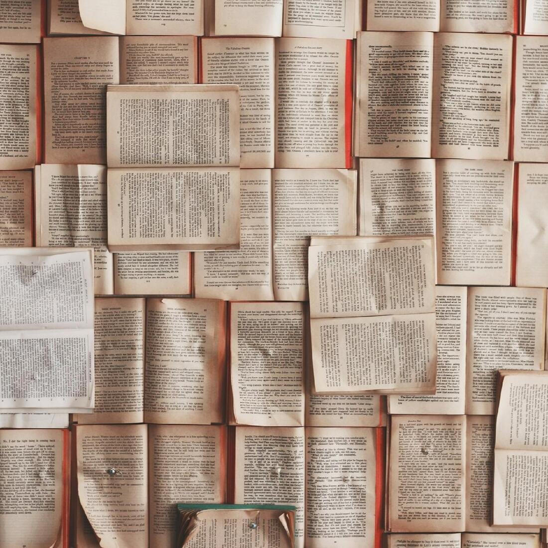 Pared cubierta de libros abiertos, con sus páginas amarillentas una junto a otra